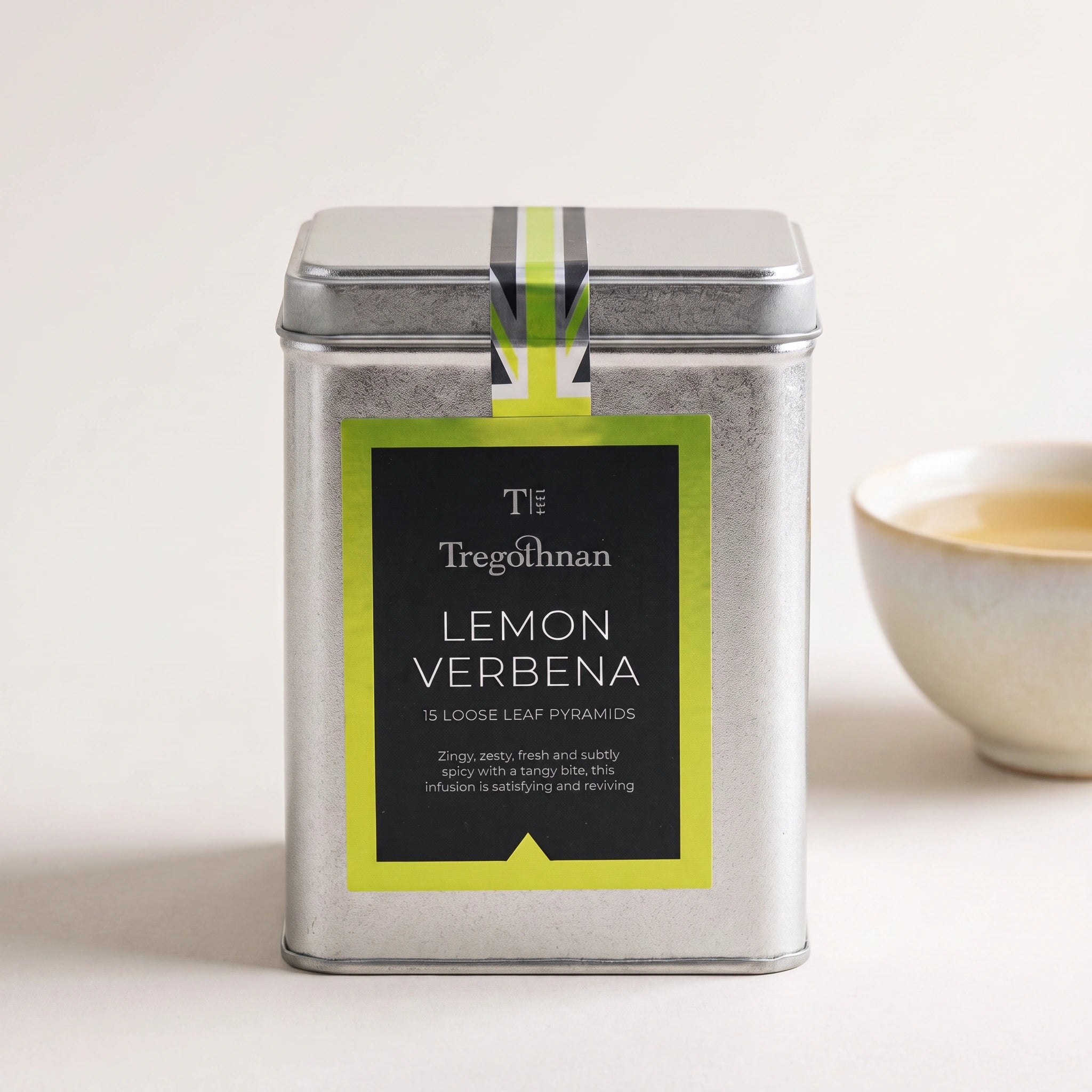 Tregothnan Lemon Verbena tea tin front-on with a cup of herbal tea