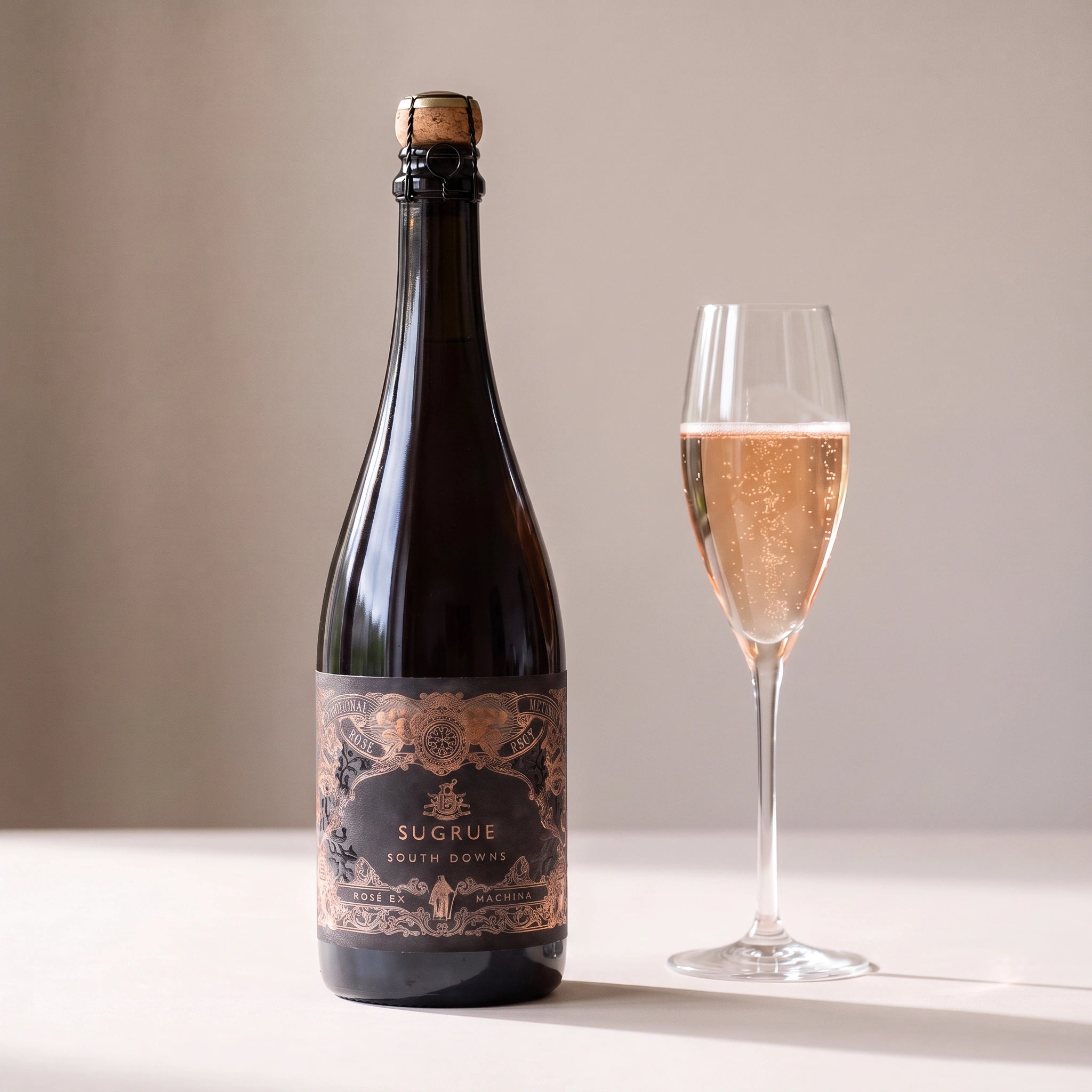 Sugrue South Downs Rosé Ex Machina bottle with a glass of blush sparkling rosé