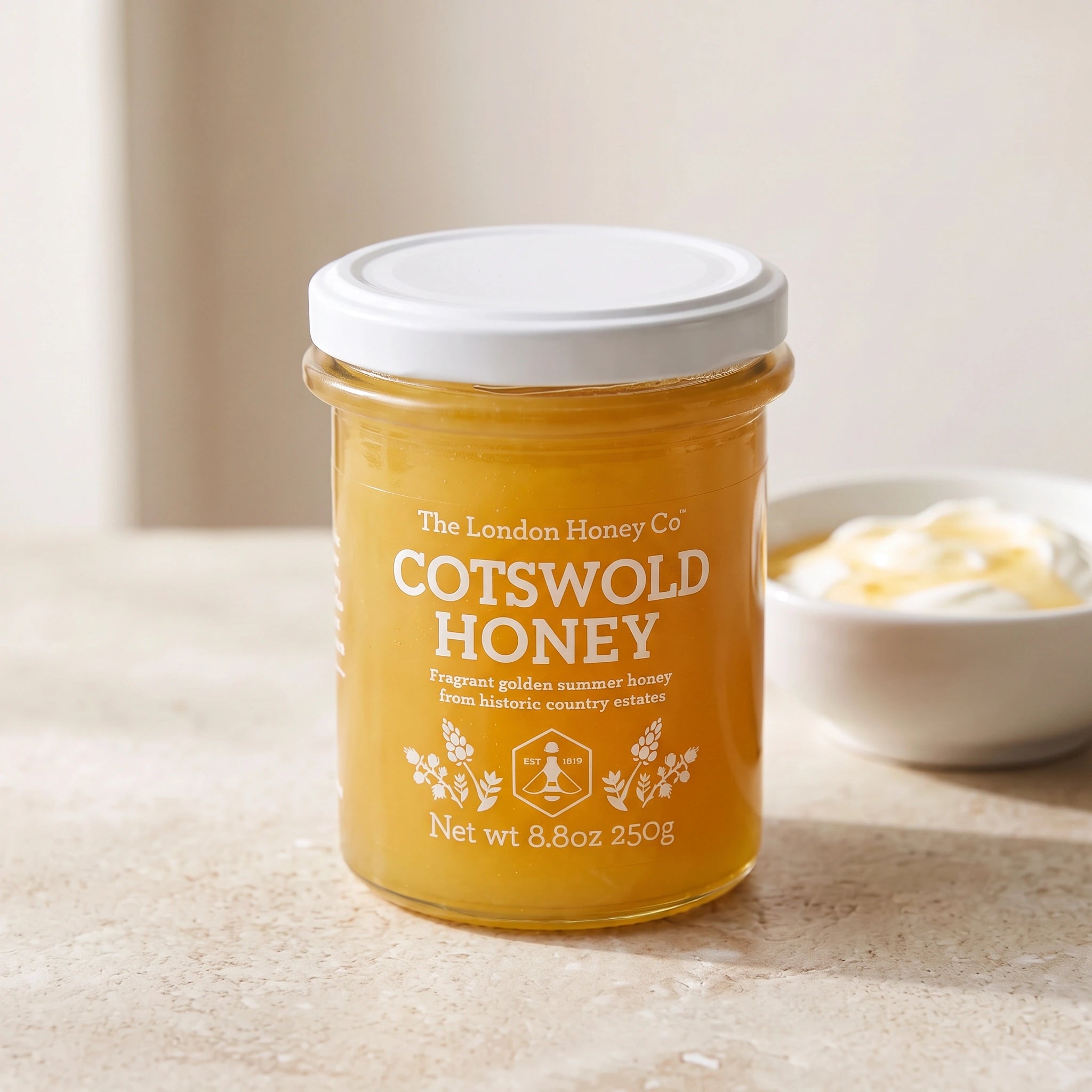 The London Honey Co Cotswold Honey jar with a bowl of yoghurt and honey