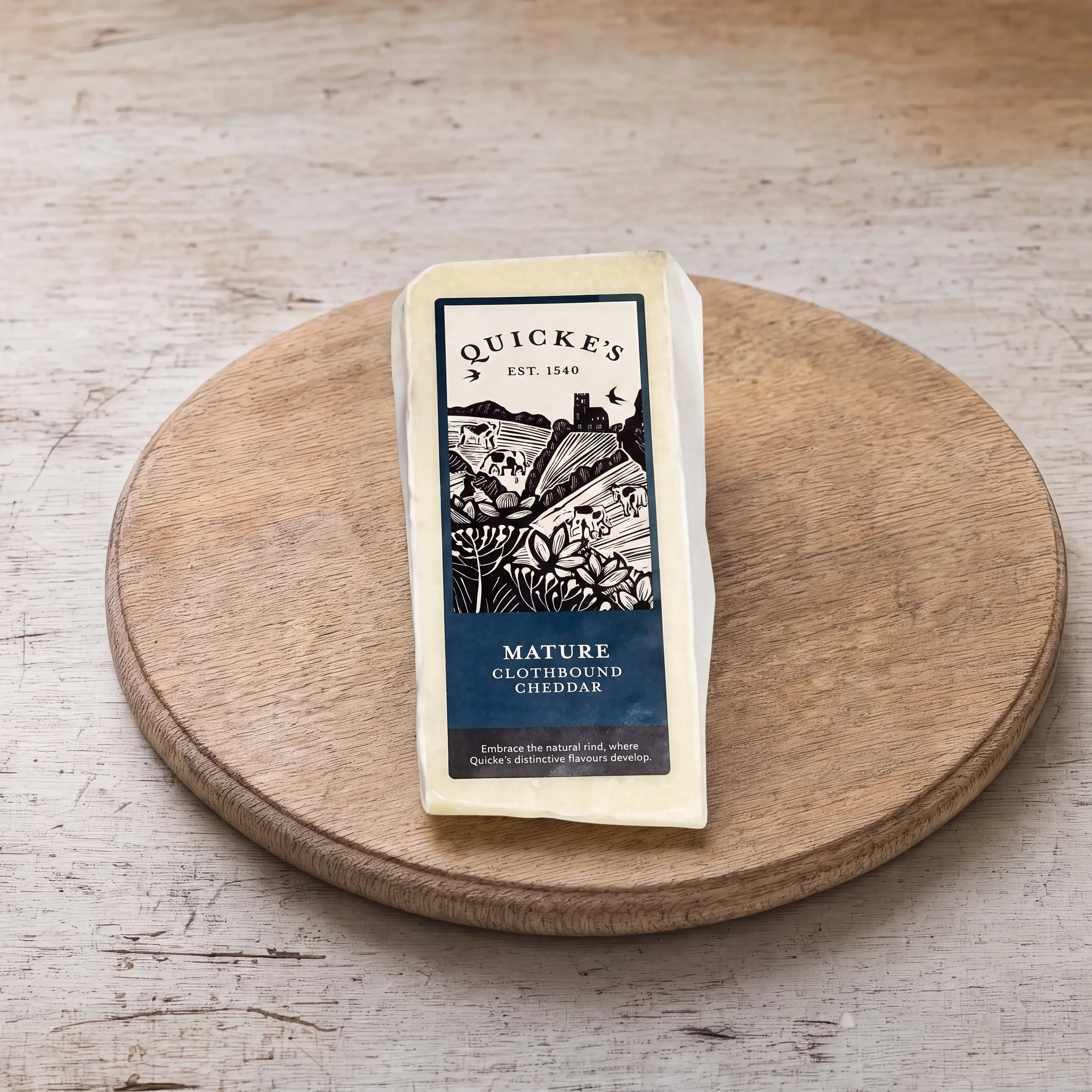 Quicke's Mature Clothbound Cheddar on an oak board
