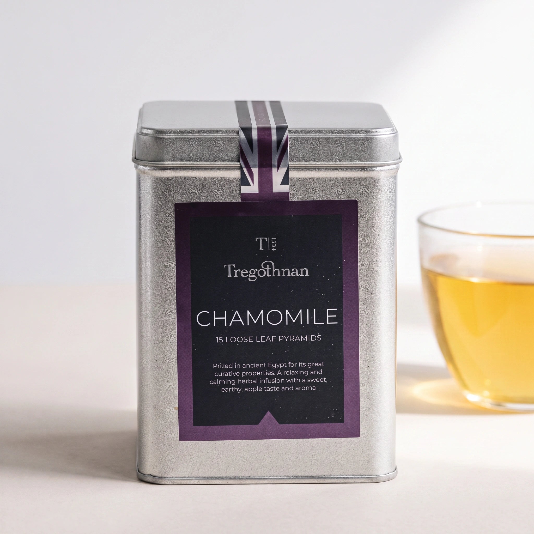 Tregothnan Chamomile tea tin front-on with a cup of golden chamomile tea