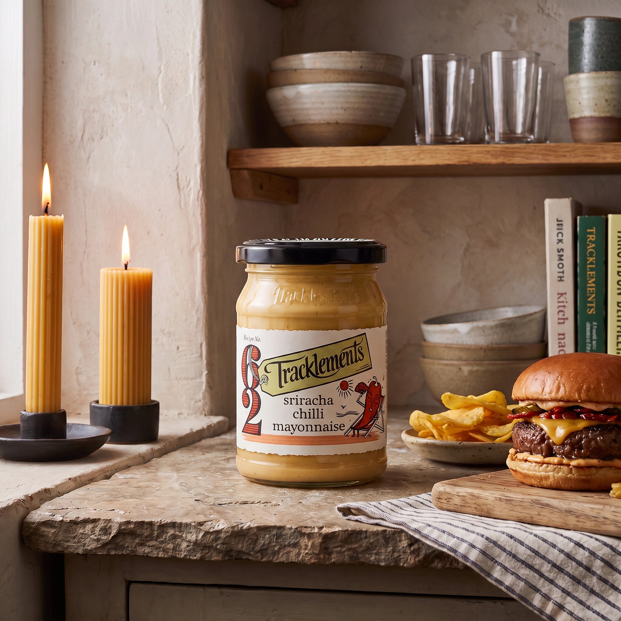 Tracklements Sriracha Chilli Mayonnaise jar in a rustic kitchen setting with a burger and chips