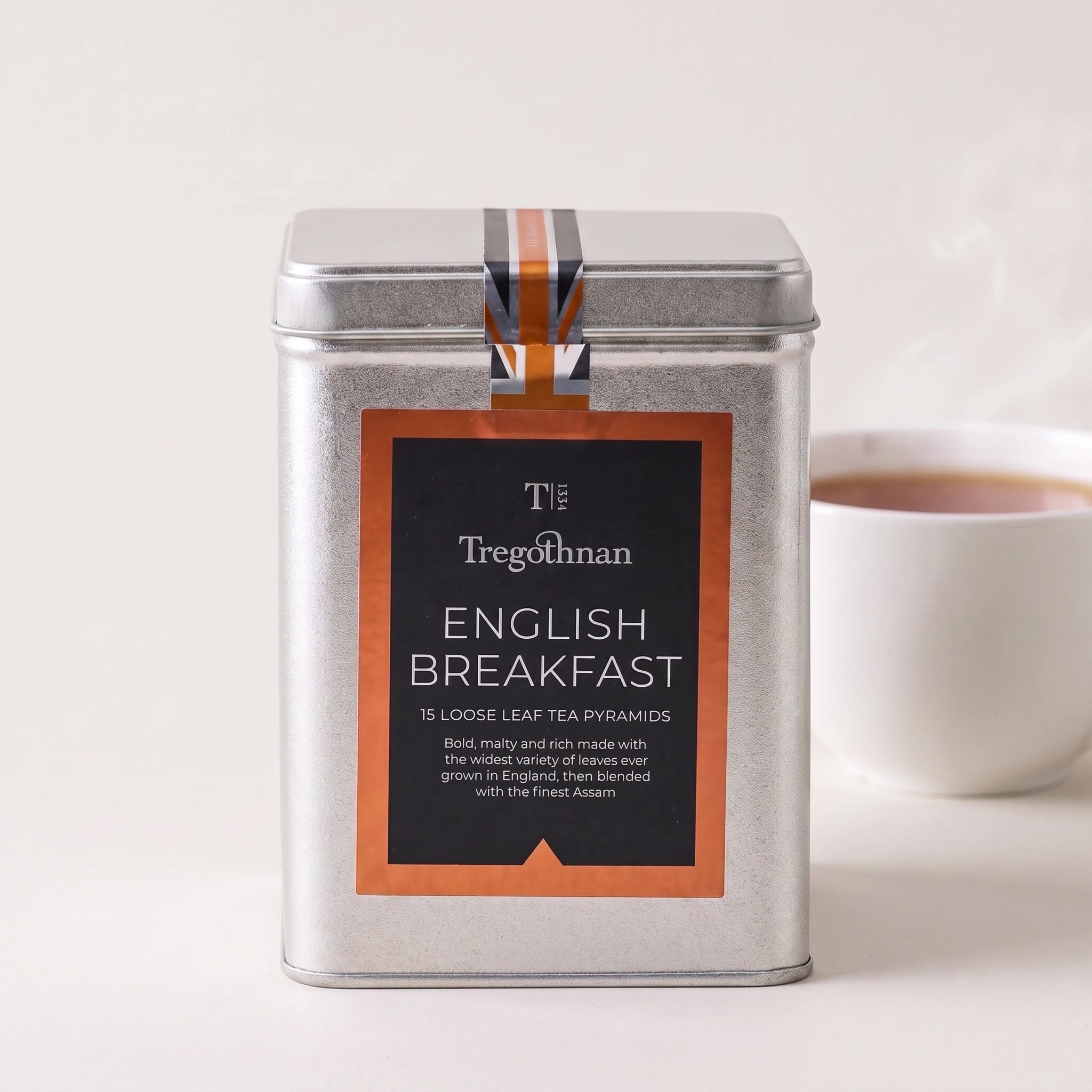 Tregothnan English Breakfast loose leaf tea tin front-on with a cup of amber tea