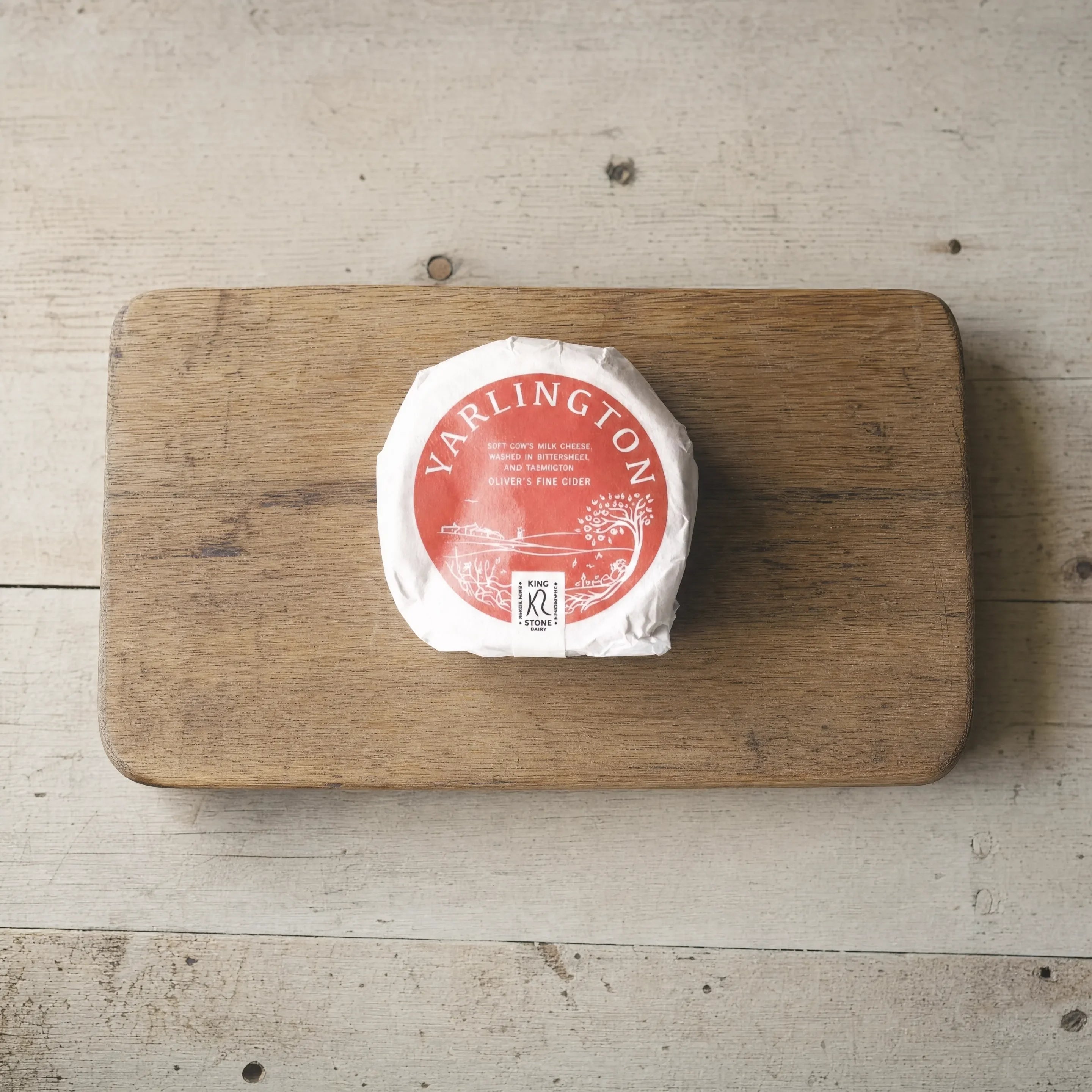 Yarlington washed-rind cheese on an oak board, English cheesemonger counter