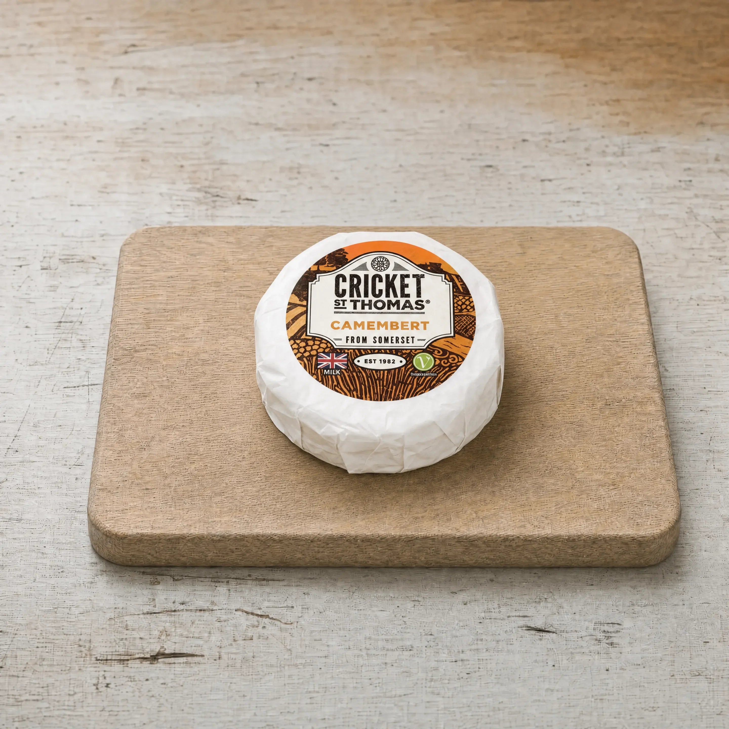 Cricket St Thomas Somerset Camembert on an oak board, English cheesemonger counter