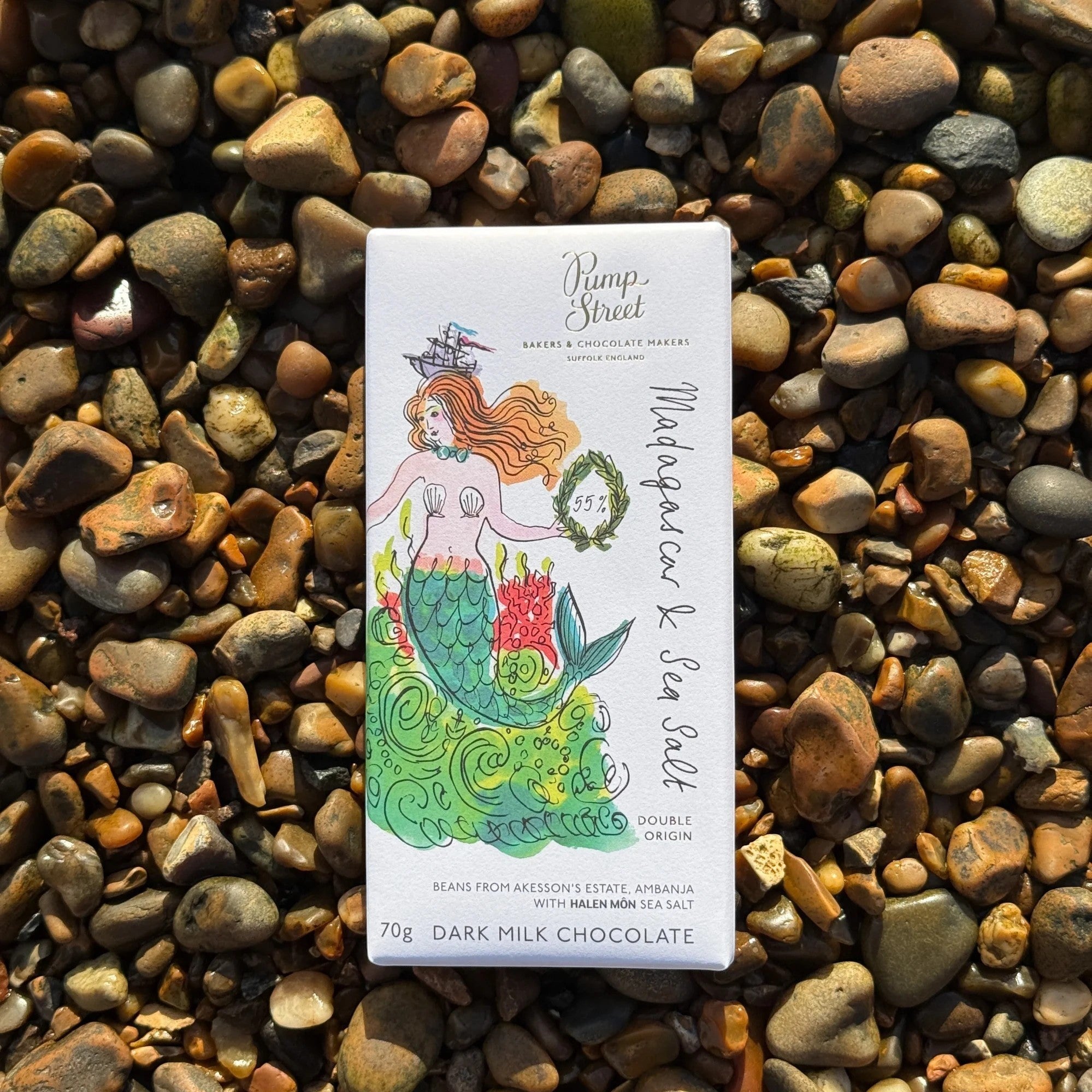 Made In England Pump Street 55% Dark Milk Chocolate Madagascar & Sea Salt bar with mermaid illustration on a pebble beach.