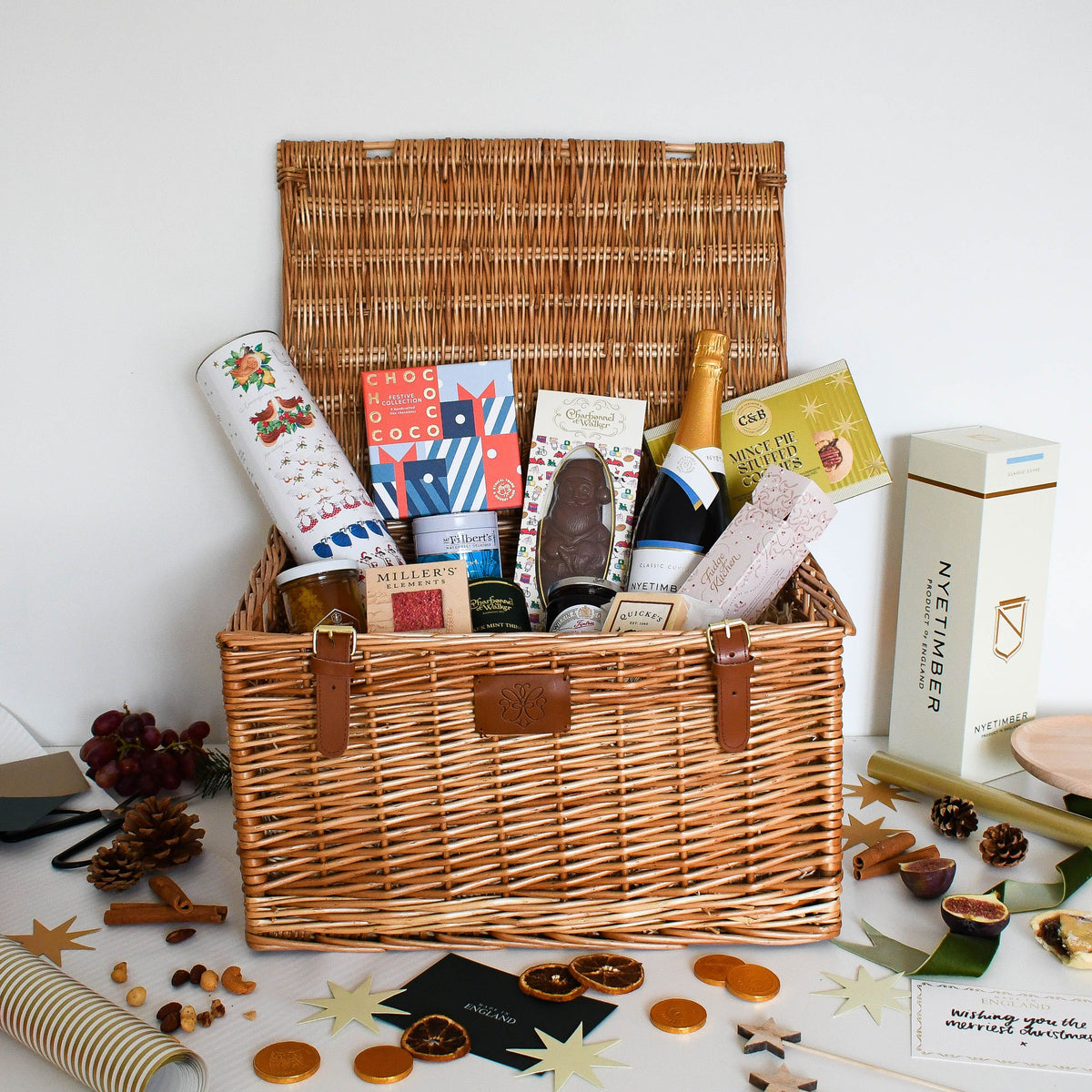 A Very English Christmas Hamper with Nyetimber Classic Cuvée, chocolates, fudge, crackers and preserves in a wicker basket