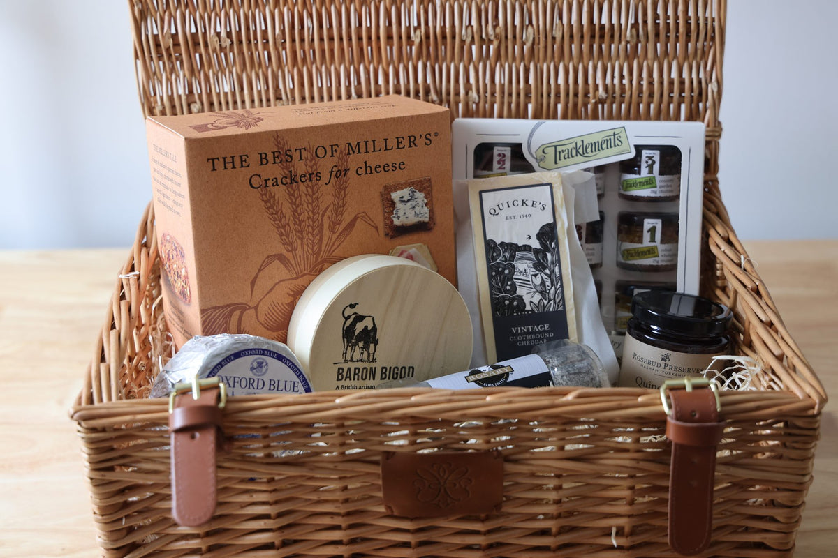 English cheese hamper in a wicker basket with Baron Bigod, Oxford Blue, Quicke's cheddar and Miller's crackers