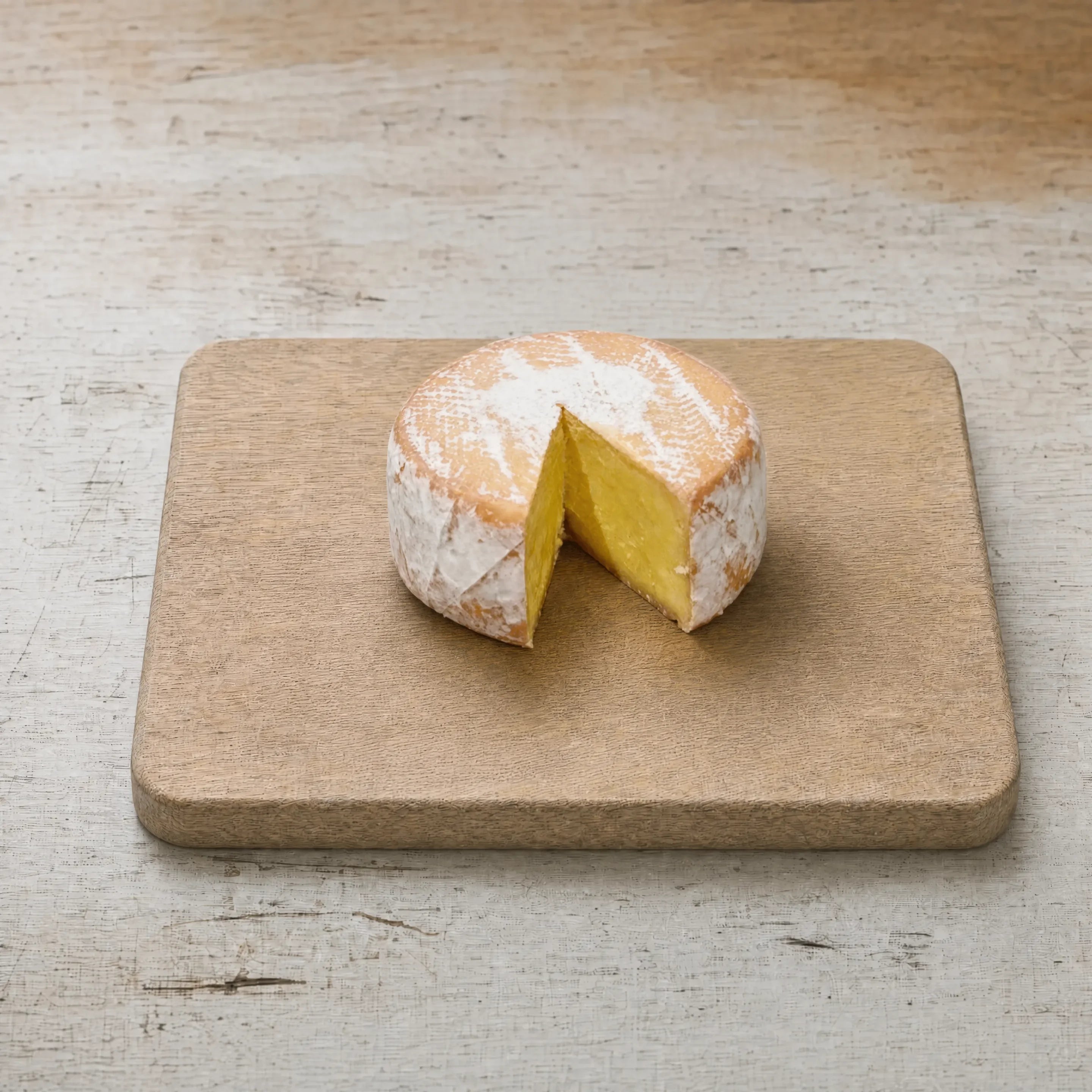 Maida Vale washed-rind cheese on an oak board, English cheesemonger counter