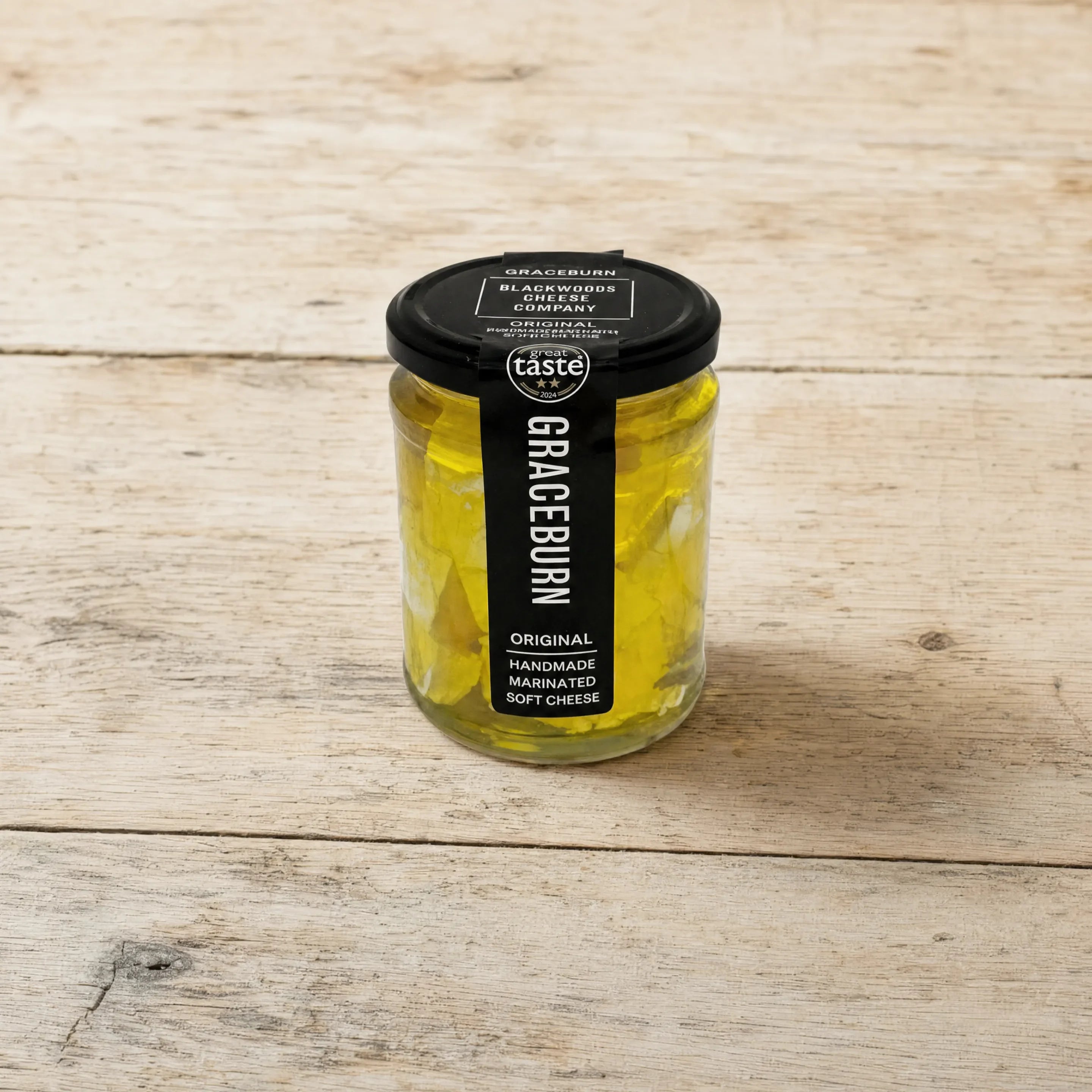 Graceburn marinated soft cheese jar on an English cheesemonger counter