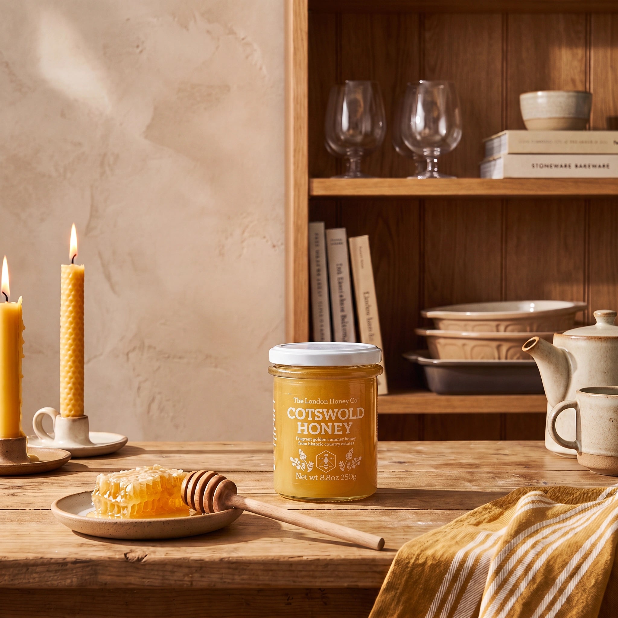 The London Honey Co. British Cotswold Honey jar in a rustic kitchen setting with honeycomb and tea