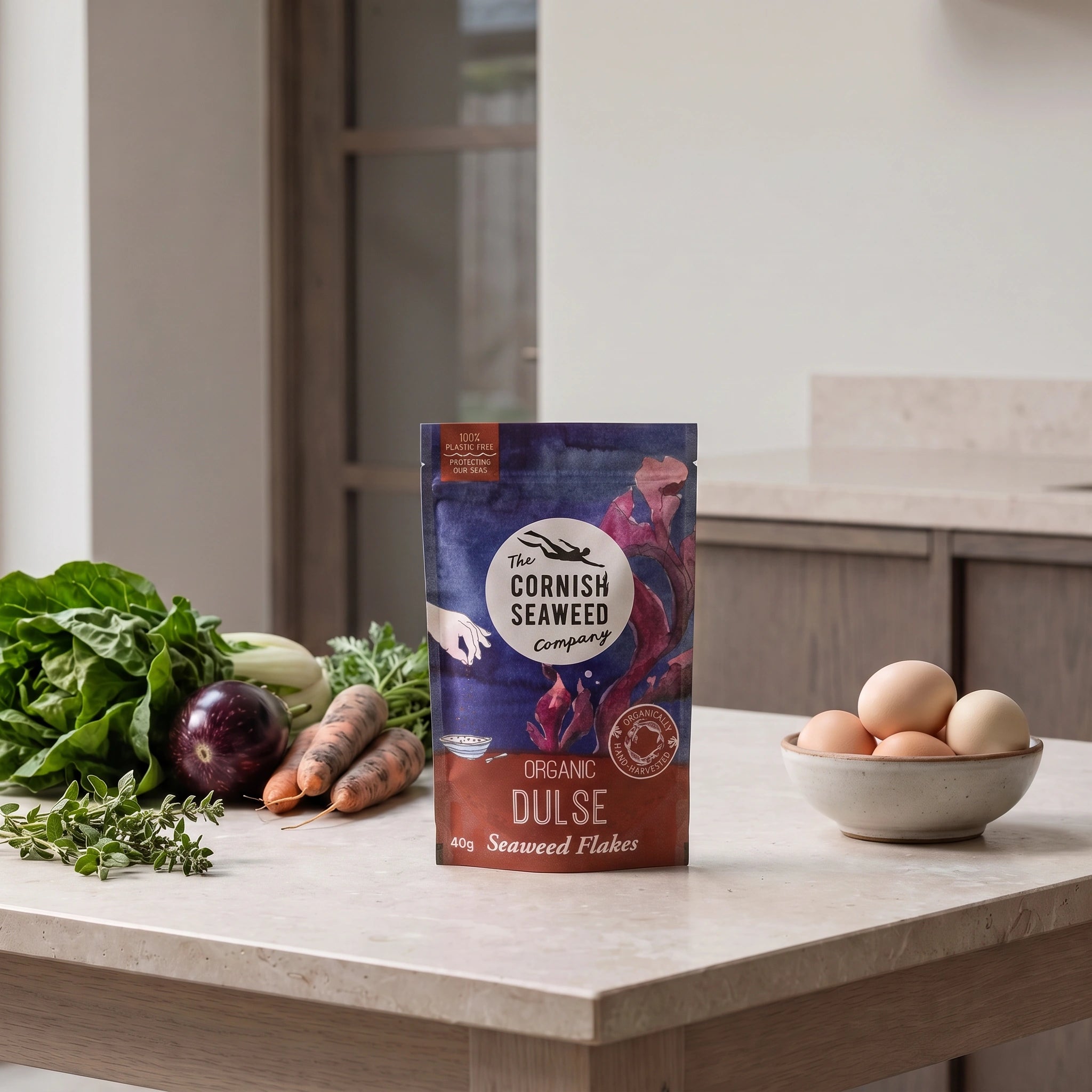 The Cornish Seaweed Company Organic Dulse Flakes pouch in a minimalist stone dining setting