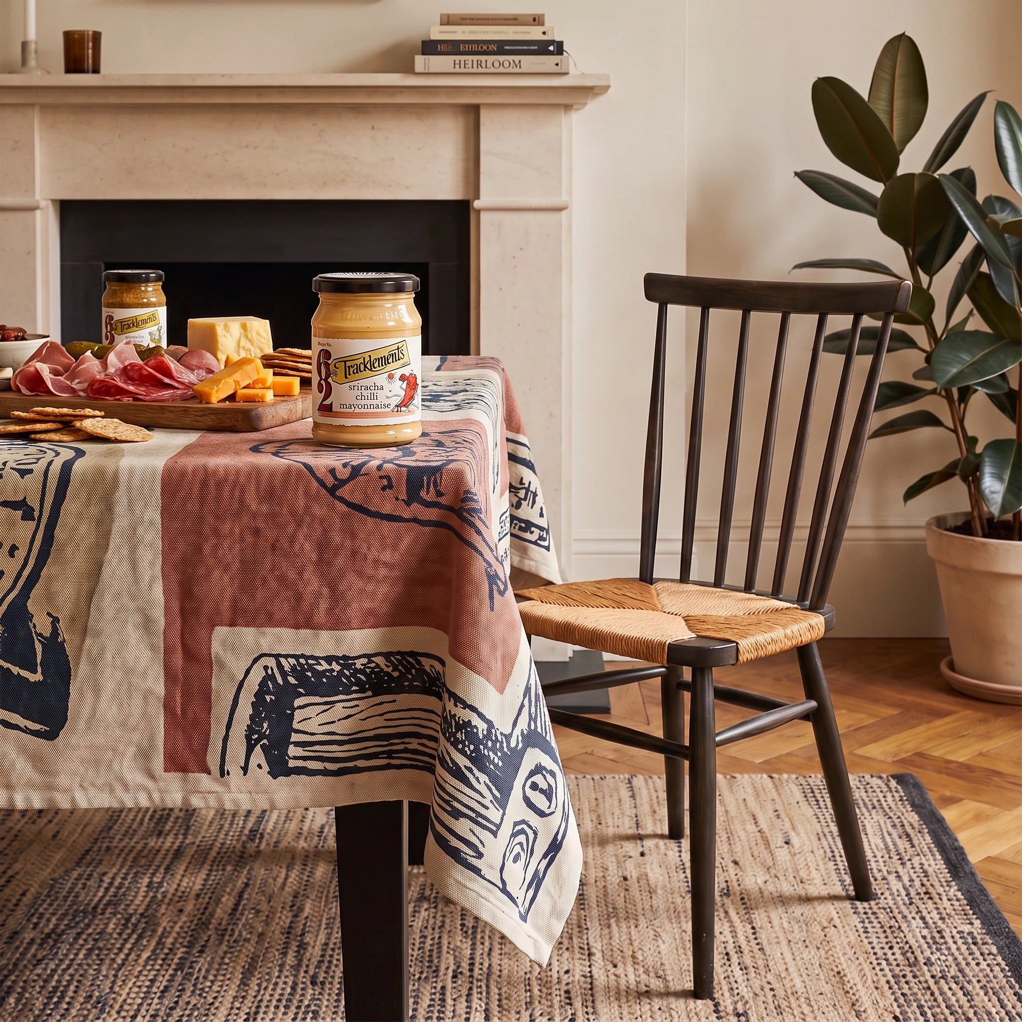 Tracklements Sriracha Chilli Mayonnaise jar on a fireside table with a charcuterie board