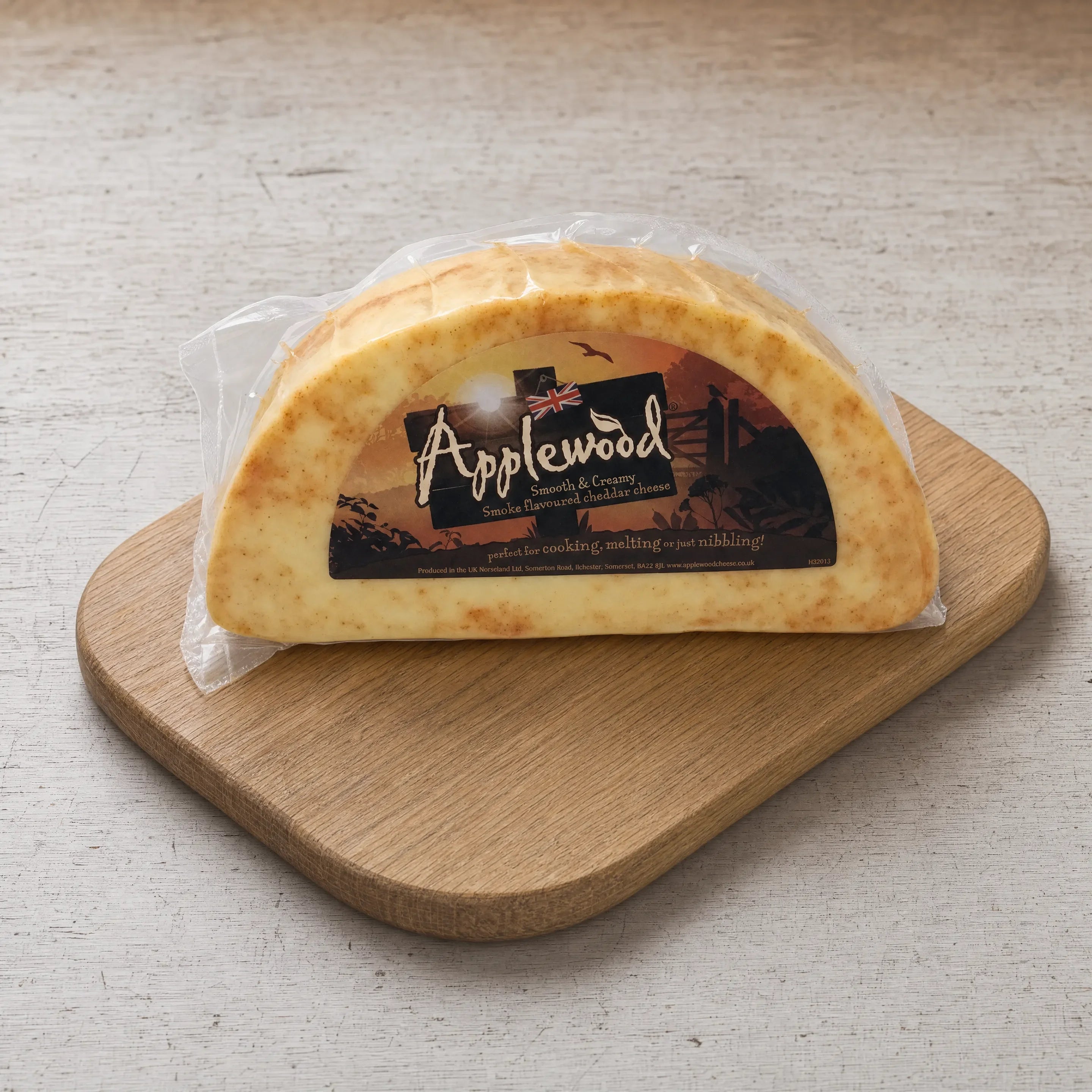 Applewood smoked cheese in its packaging on an oak board