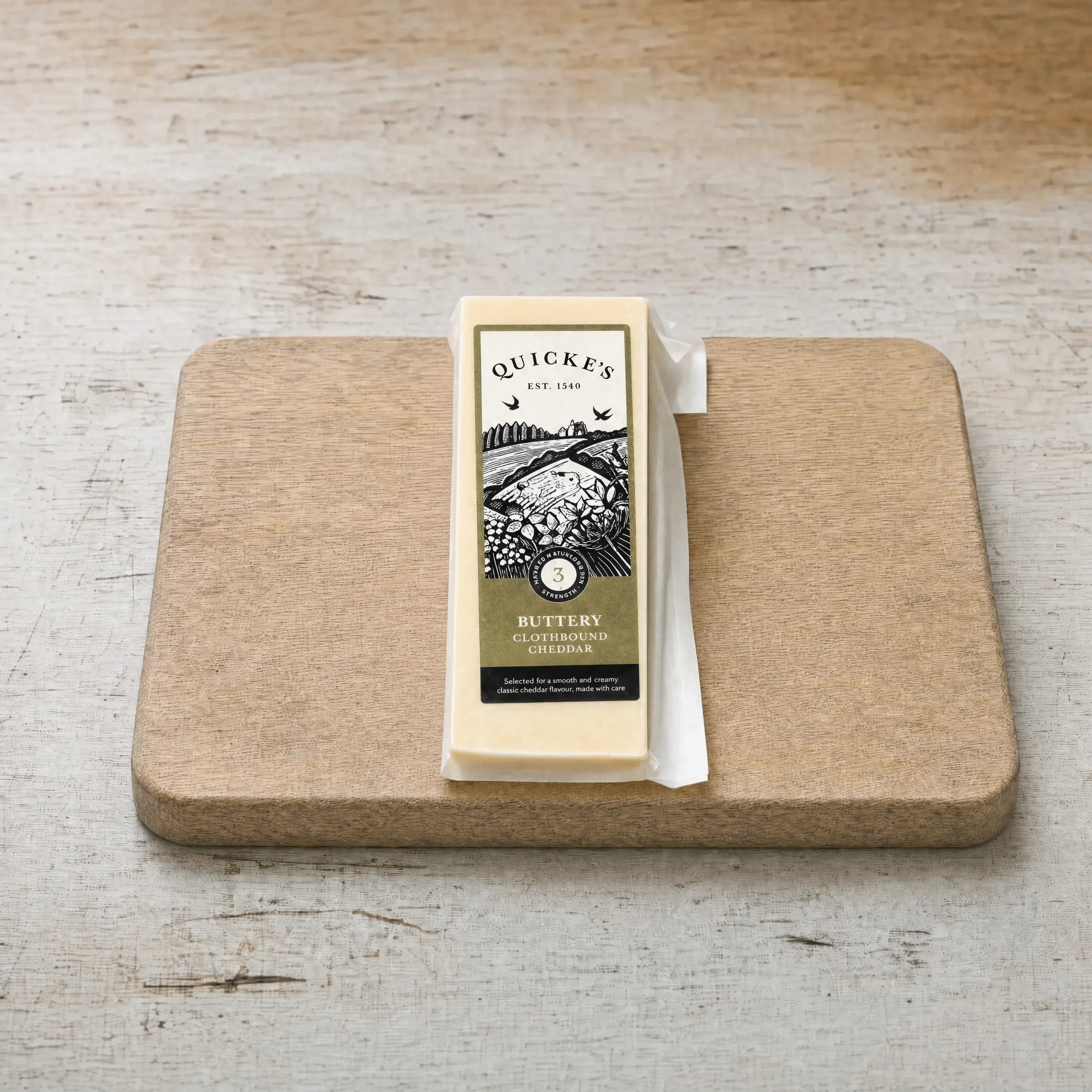 Quicke's Buttery Clothbound Cheddar on an oak board