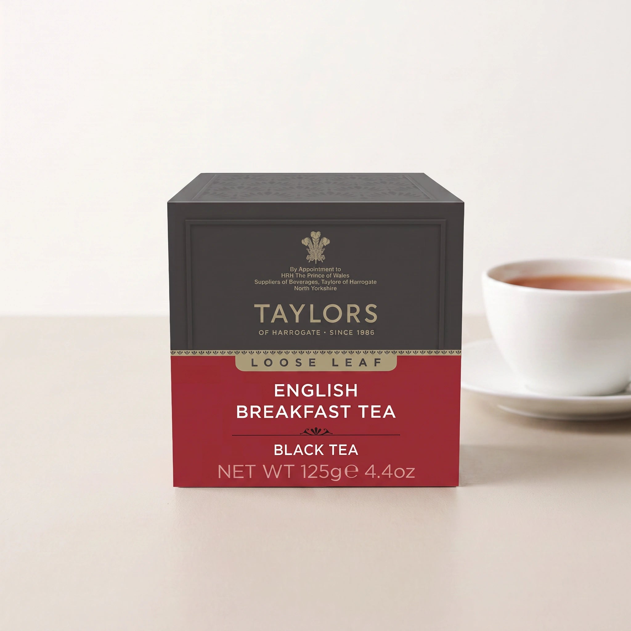 Taylors of Harrogate Loose Leaf English Breakfast tea pack front-on with a cup of tea
