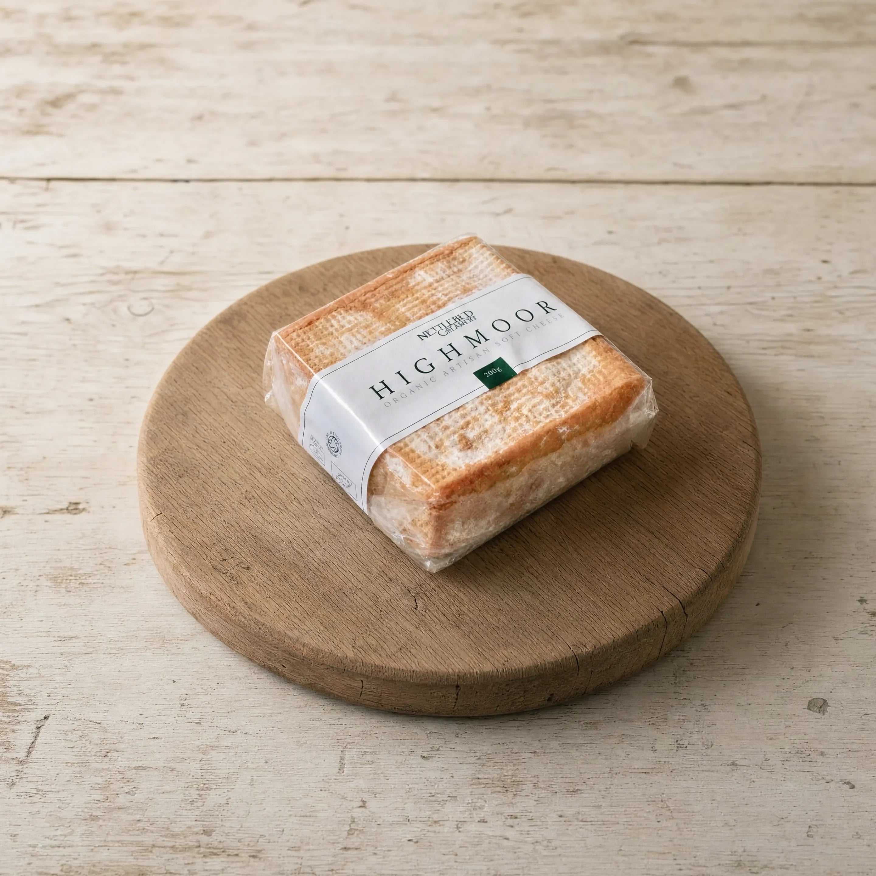 Highmoor organic soft cheese on an oak board, English cheesemonger counter
