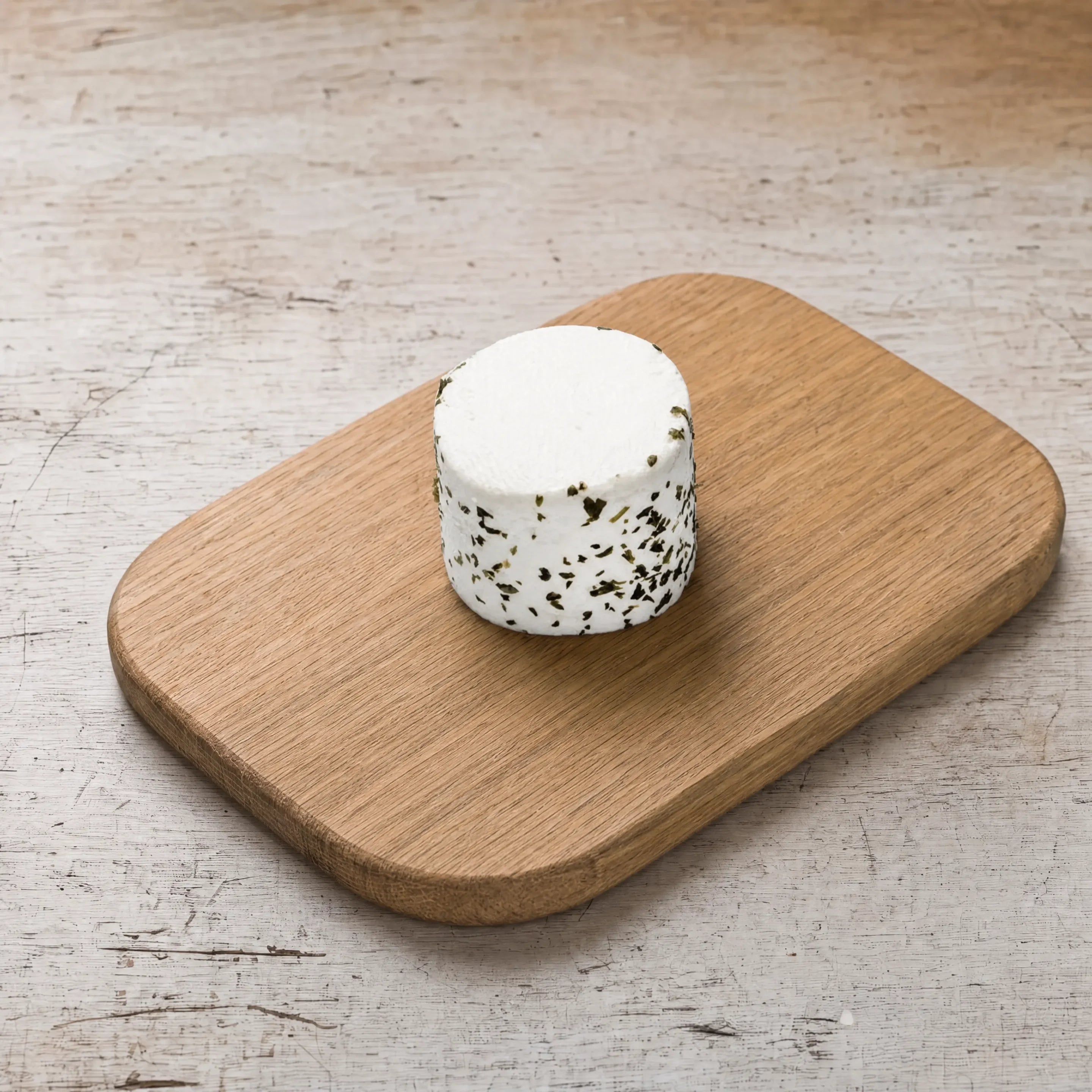 Rosary garlic and herb goats' cheese drum on an oak board