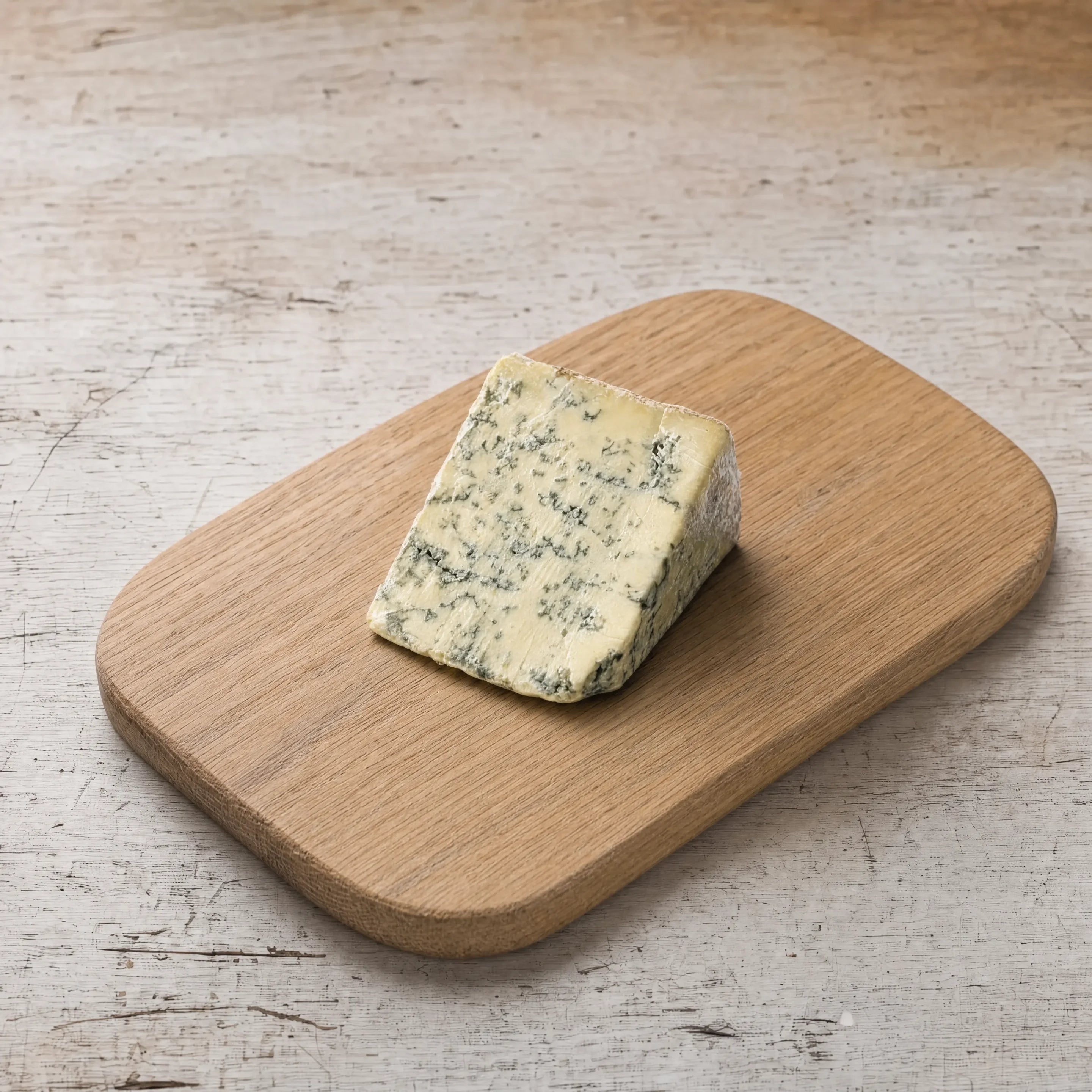 Long Clawson Blue Stilton wedge on an oak board, English cheesemonger counter