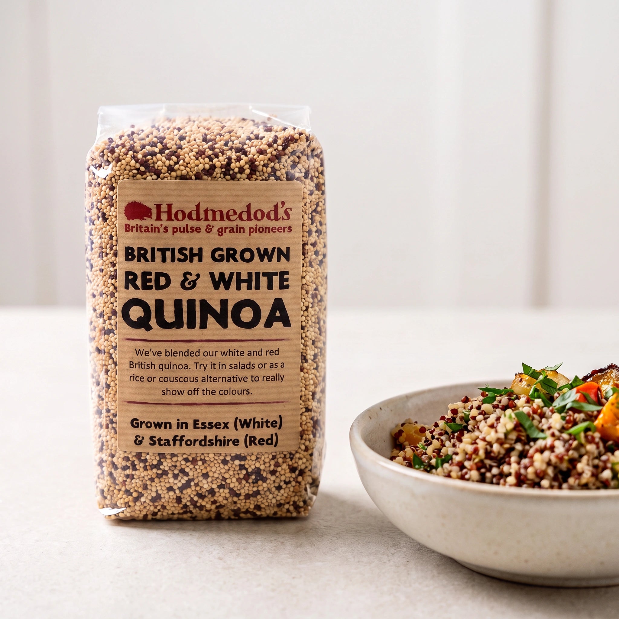 Hodmedod's British Grown Red & White Quinoa pack with a bowl of quinoa salad