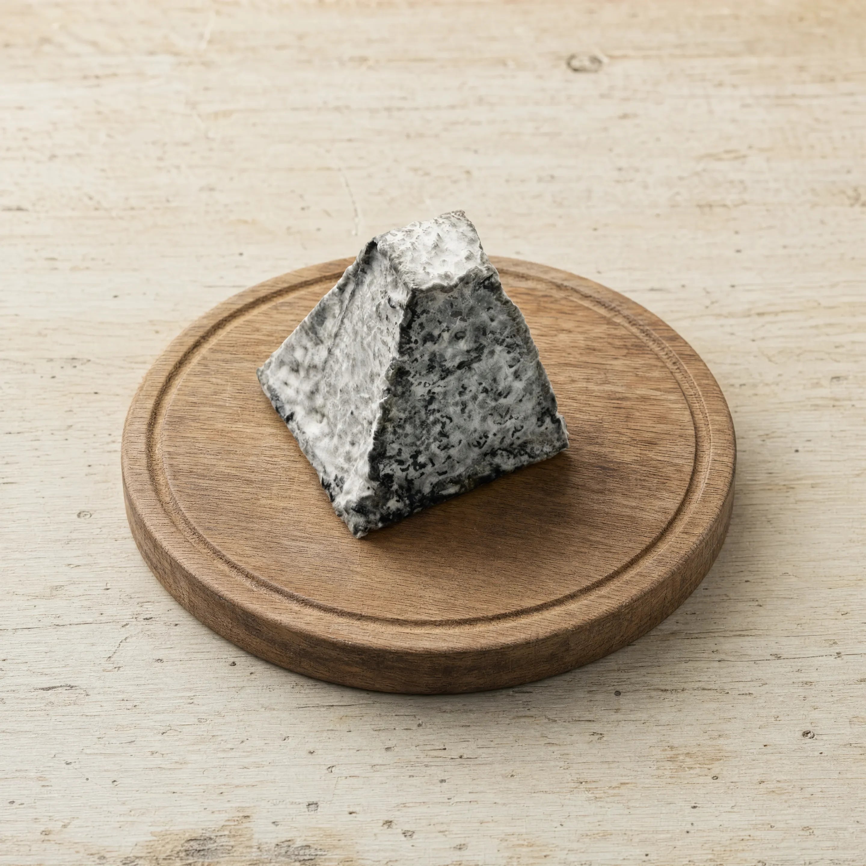 Tor goat ash pyramid on an oak board, English cheesemonger counter
