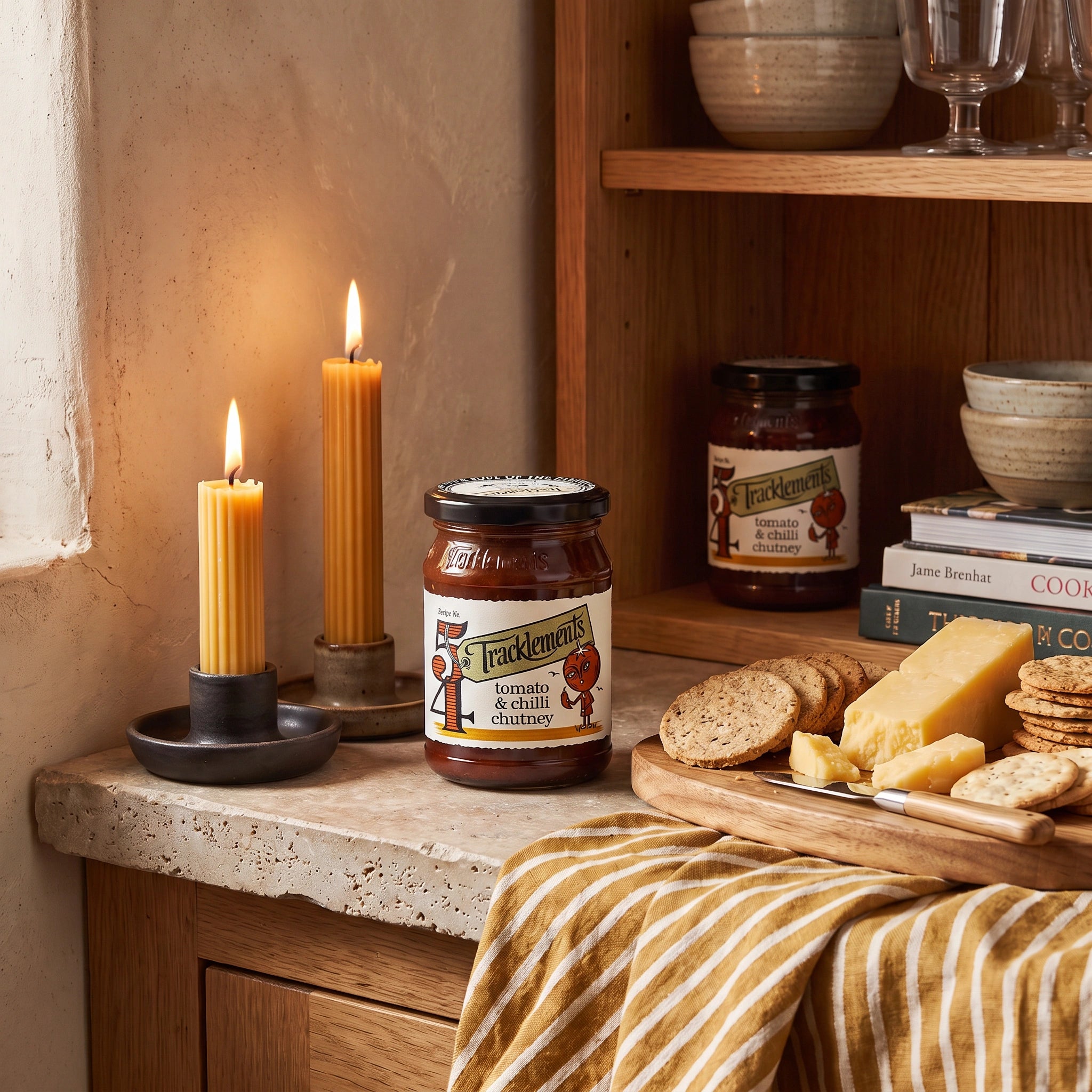 Tracklements Tomato & Chilli Chutney jar in a rustic kitchen setting with a cheeseboard