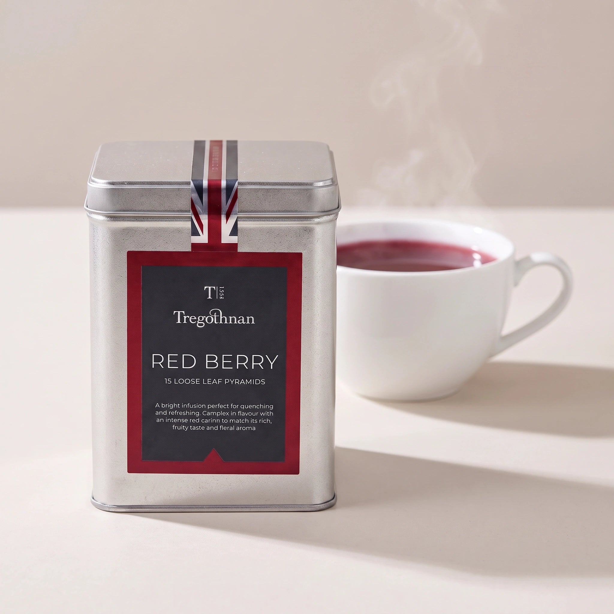 Tregothnan Red Berry tea tin front-on with a cup of red berry infusion