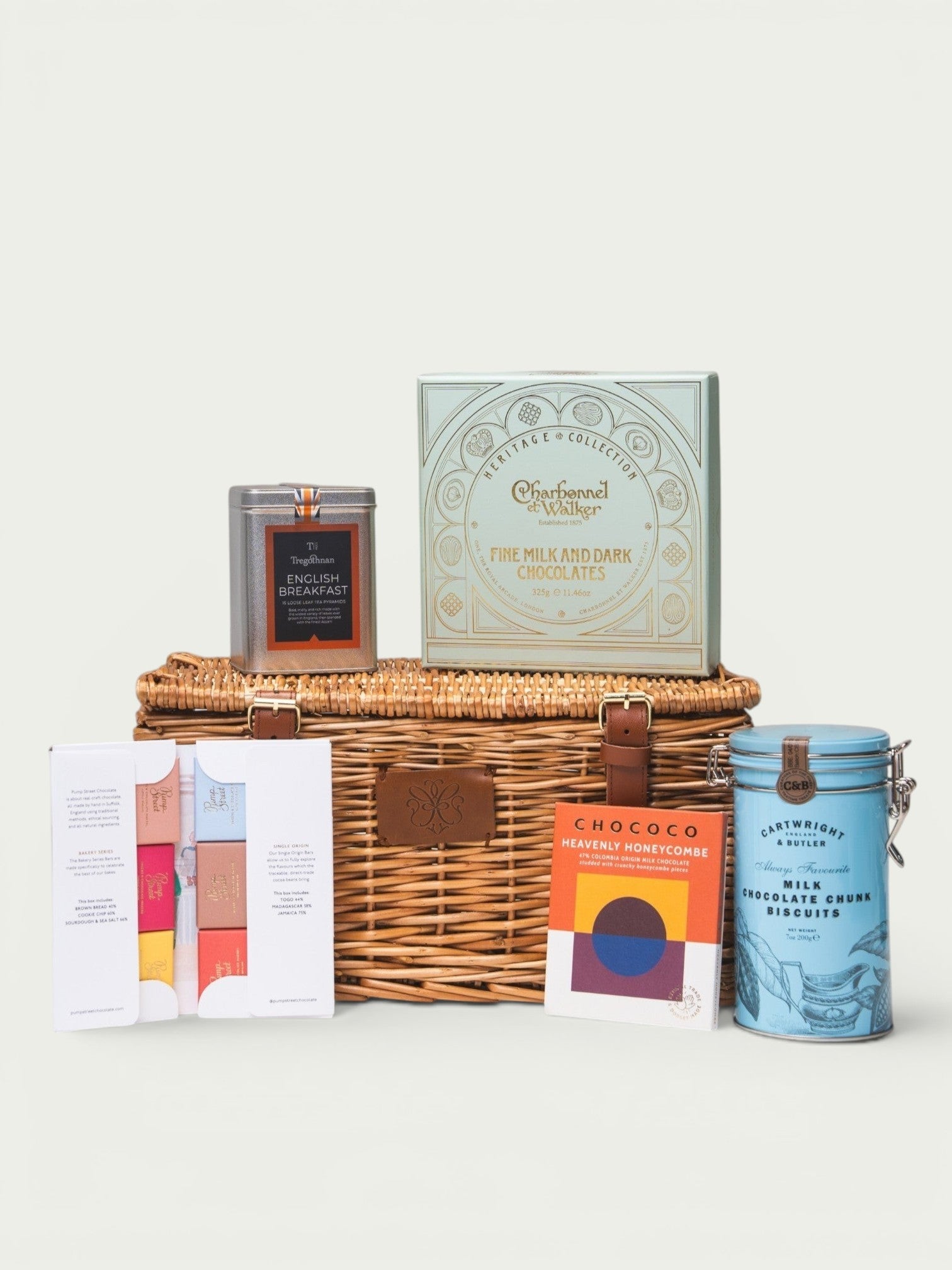 Made In England Artisan Chocolate and Tea Gift Hamper in woven basket with Charbonnel et Walker chocolates, Chococo honeycomb, Cartwright & Butler biscuits, and Tregothnan tea.